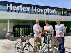 Vicedirektør i Cyklistforbundet, Jane Kofod, overrækker prisen til hospitalsdirektør Niels Würgler Hansen (tv) og fysioterapeut og næstformand i Virksomheds MED-udvalget (VMU) Anders Breinholt Nielsen.