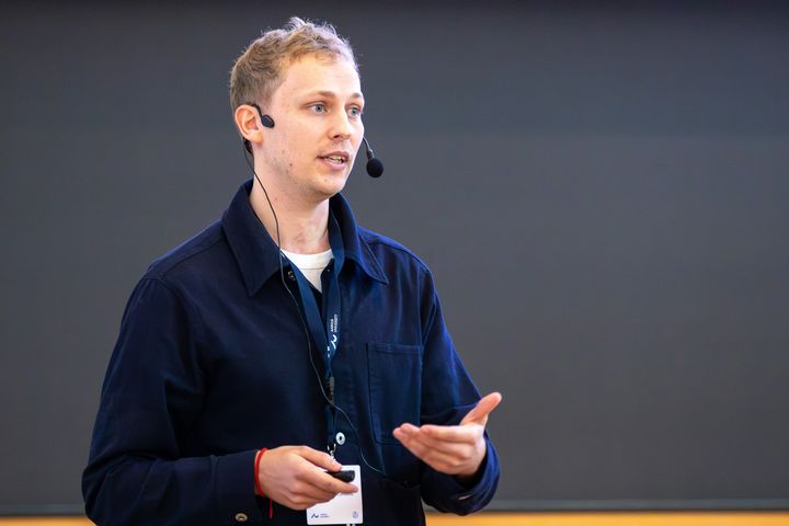 Martin Qvist Rasmussen vandt dette års Fogh-Nielsen-konkurrence med en veloplagt præsentation foran et fyldt Per Kirkeby Auditorium til PhD Day. Foto: Simon Fischel, AU Health.