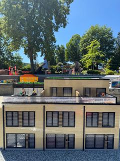 LEGO miniature modellerne af området ved Københavns Havn er så småt begyndt at flytte ud i parken. Her ses rækkehuset bygget i LEGO, som Rasmus, Mads og Johan bor i. LEGO figurene af familien flytter snart ind.