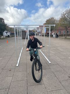 En af øvelserne på den mobile cykelbane er porten, som man skal køre igennem med kroppen nedbøjet over styret. Her er Anton kommet igennem øvelsen i god stil.