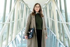 Genrefoto med ung kvinde med computer under armen