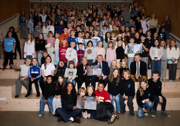 Udenrigsminister Lars Løkke Rasmussen, PlanBørnefondens direktør Dorthe Petersen samt sanger og rapper Karen Mukupa og FVN viser året U-landskalender frem med elever fra Christianshavns Skole.