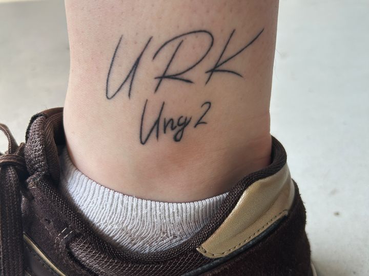 Super-Sofie%20viser%20sin%20tatovering%20frem%3A%20URK%20st%E5r%20for%20Ungdommens%20R%F8de%20Kors.%20Og%20Ung%202%20er%20navnet%20p%E5%20den%20Ferielejr%20ved%20Viborg%2C%20hvor%20Sofie%20var%20med%20som%20barn%2C%20og%20hvor%20hun%20i%20dag%20er%20frivillig.
