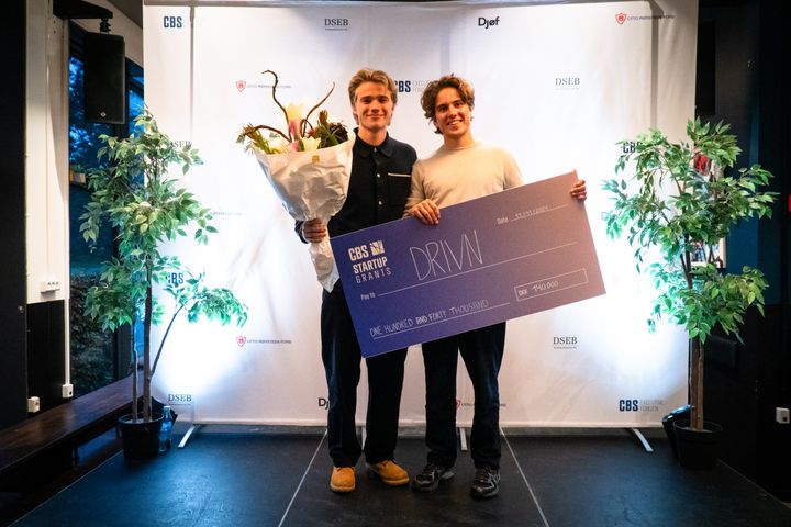 Sebastian Herche i mørk bluse med kammeraten og kompagnonen kammeraten, Nikolaj Mackenzie, bliver kåret som en af vinderne af CBS Startup Award.