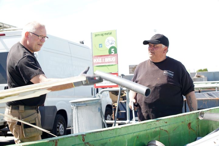 Håndværker og medarbejder på Haarby genbrugsplads står sammen ved container fyldt med byggeaffald.