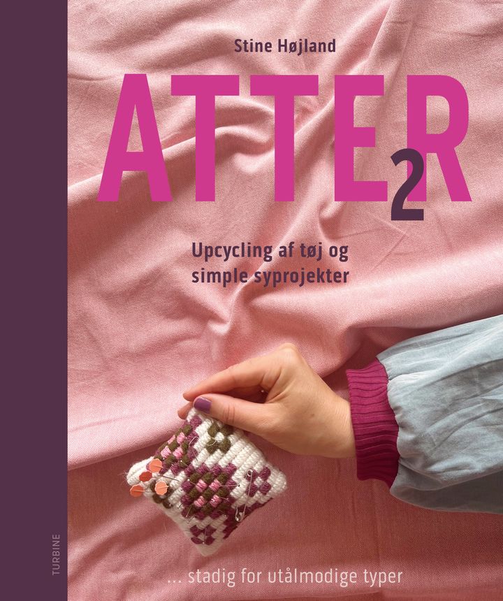 En hånd holder et lille, broderet pudestykke på en lyserød baggrund. Teksten på forsiden siger "Atter 2" af Stine Højland.