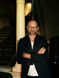 Portræt at forfatter Christian Unge, der står med korslagte arme.