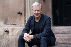 Steffen Kretz sidder på en trappe iført en mørk jakkesæt.