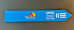 Blåt mærkat med logo fra Dansk Blindesamfund og teksten: Ups! Jeg står på en ledelinje. Flyt mig