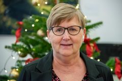 Portræt af Gitte Micheelsen foran et pyntet juletræ