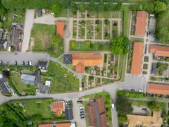 Droneskud af Lisbjerg Kirke i centrum. Her lå i vikingetiden en stormandsgård indhegnet af et palisadehegn.