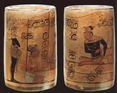Keramisk drikkebæger til kakao med afbildning af en paladsscene. På tronen sidder herskeren Aj Sak Bopat, og foran ham ses bl.a. tronarvingen og to præster. Sen klassisk tid, 600-800 e.v.t., fra El Señor del Peten i Campeche, Mexico. Ligesom jade var kakao en sjælden og værdifuld ressource. For selv om kakaoplanten vokser mange steder, så er den kræsen og kræver adgang til bestemte områder og ressourcer. Derfor var muligheden for at indtage den et udtryk for rigdom og særlig status.