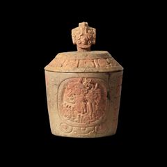 Denne krukke er ifølge teksten på låget beregnet til kakao. På siden af selve krukken ses Yuknom Ch’en II (Yuknom den Store), der herskede i Calakmul i 50 år, som kaldes en af de mest magtfulde herskere i mayakulturen. 672 e.v.t., Calakmul, Mexico.