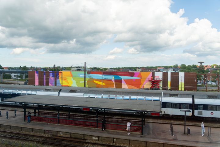Den tyske kunstner Stohead er her i fuld gang med at male den 100 meter lange og 9 meter høje facade på DSBs vaskehal.