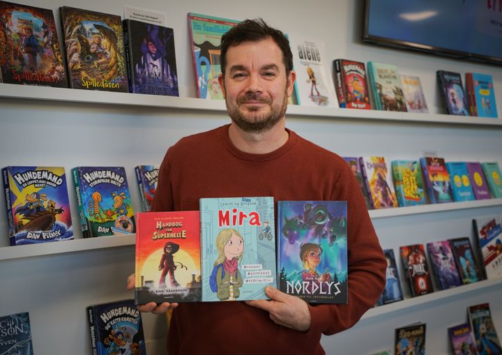 Kulturformidler Martin Rovang foran tegneserievæggen på Næstved Bibliotek. Lånerne tog næsten tre gange så mange tegneserier med hjem i 2025 som i 2022.