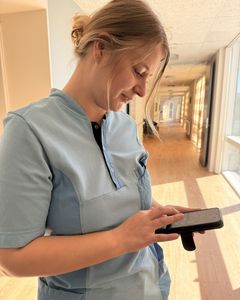 Diana og hendes kolleger på plejehjemmet Kildemarkscentret kan på mobiltelefonens skærm følge beboerne i deres bolig gennem piktogrammer. Her kan de se, hvornår de ældre har brug for hjælp, og om de sover og ikke skal forstyrres.