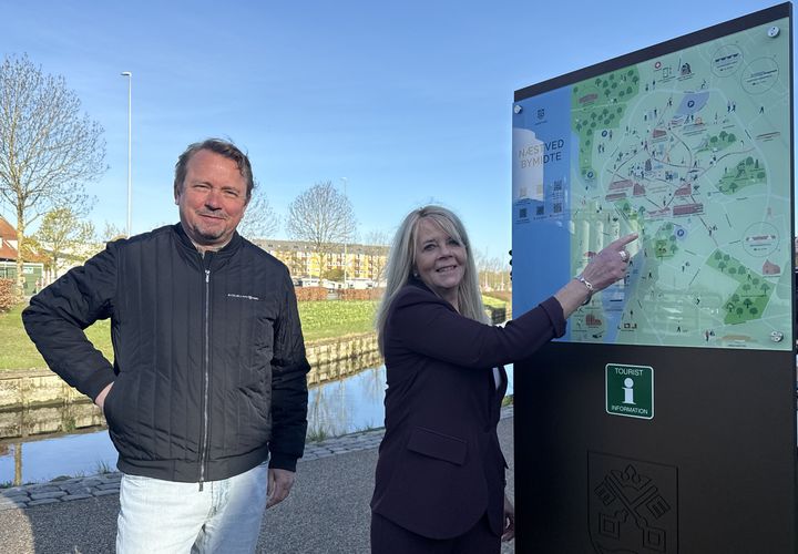 Et af de ni nye oplevelsesskilte er opsat ved Den Fritlagte Suså, og Formand for Beskæftigelses-, Erhvervs- og Turismeudvalget, Githa Nelander, glæder sig sammen med direktør Martin HH Bender, Visit Sydsjælland & Møn, over, at skiltene synliggør de mange oplevelser, Næstved Kommune har at byde på. Foto: Næstved Kommune