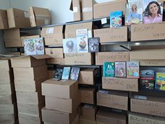 Stakke af papkasser med bøger og skilte til bogsalg