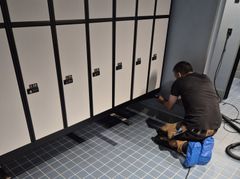 Person installerer bænk foran omklædningsskabe i Kampsportens Hus på Nørrebro.