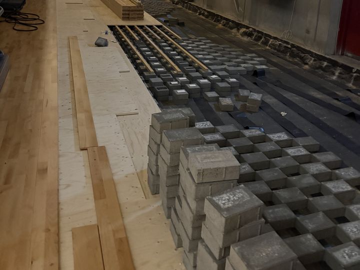 Et%20gulv%20bliver%20udskiftet%20med%20stakke%20af%20fliser%20og%20tr%E6planker%20i%20Valby%20Hallen.