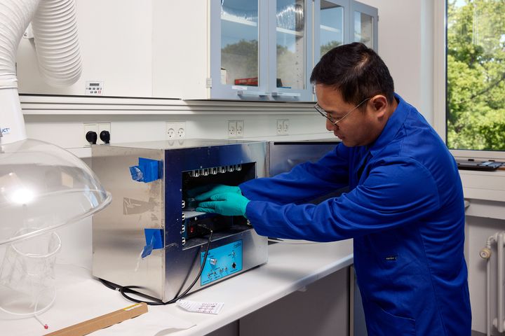 Lektor Zongsu Wei, der her placerer reaktorer indeholdende en PFAS-opløsning og katalysatorer i en laboratorieenhed til UV-strålingsbehandling, leder udviklingen af nye PFAS-målrettede rensningsteknologier på Aarhus Universitet.