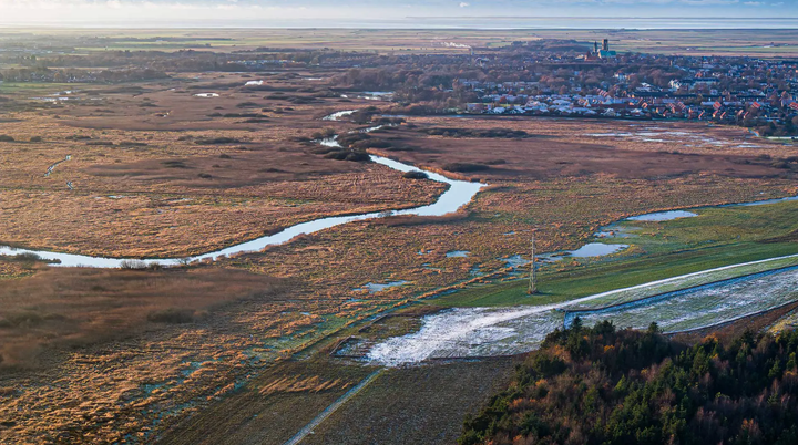 Luftfoto af det karakteristiske landskab omkring Ribe med ådale, marsk og vådområder tæt forbundet med Vadehavet.