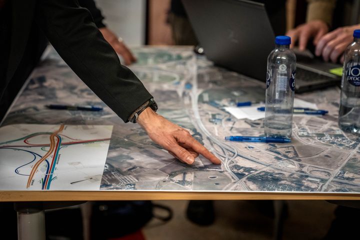 En borger peger på et stort strækningskort.