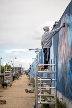 Maling af street art på byggepladshegn. Foto: Vejdirektoratet.