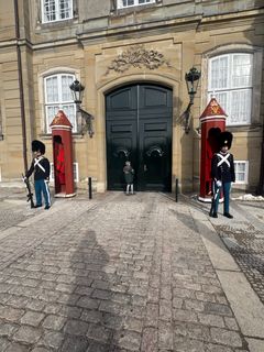 Oskar skal ind og sælge årets første Lillebrorlodder til H.M. Dronningen. Her banker han på døren ved Fr. VIII's Palæ på Amalienborg.