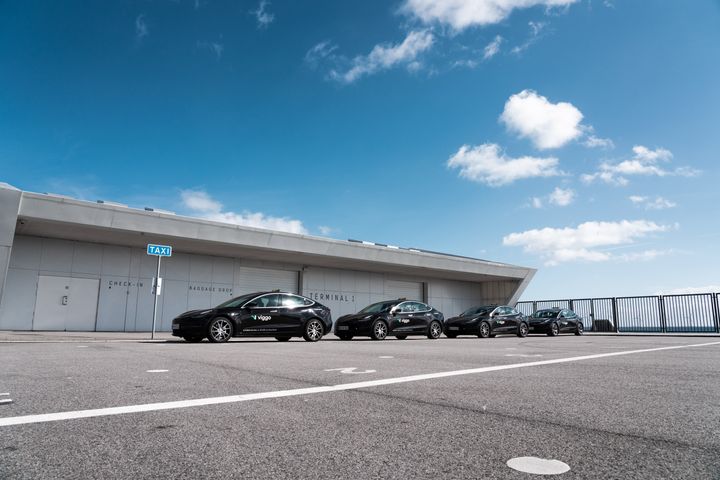 Fire sorte Viggo-biler af mærket Tesla på række i solskin ved taxiholdepladsen på Oceankaj i København
