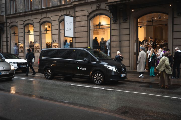 Sort Viggo Stortaxa af mærket Mercedes EQV holder parkeret central i København med mennesker omkring bilen