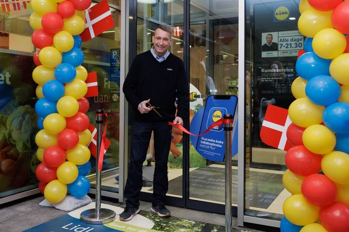 Butikschef Adam Poulsen klipper det røde bånd til den nye butik på Østerbrogade 111-113. Butikken er den første dagligvarebutik som ikke sælger tobak og nikotin i Københavns Kommune.