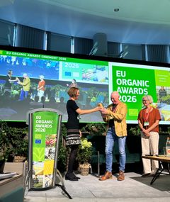 Hans Erik Jørgensen og Kirsten Rasmussen får overrakt prisen af Dóra Drexler, President of IFOAM Organics Europe.