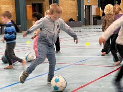 Børnene fra Børnehuset Skovly var rykket inden for i Sdr. Omme Multicenter, da de onsdag trænede fodbold sammen med en børnetræner fra DBU og en træner fra Sdr. Omme IF. Foto: Billund Kommune.