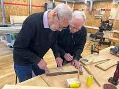 Kurt og Emil er begge med på holdet "Mandehørm". Her er de ved at aftale, hvordan skiltet skal skæres til. Foto: Billund Kommune.