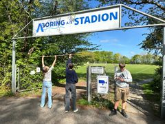 Elias, Maja og Nicoline besøgte Hejnsvig Stadion for at måle op til det store skilt, der skal markere, at Legens Festival kulminerer ved stadionet. Foto: Billund Kommune