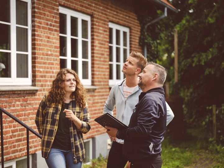 Byggesagkyndig gennemgår hus sammen med boligkøbere før boligkøb.