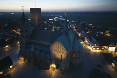 Ribe Domkirke set fra sydøst mod Esbjerg og Vadehavet med prøvebelysning på korsskibets gavl, rytterspiret og en enkelt lyskilde på Borgertårnet.