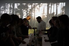 Elever i sanseværkstedet deltager i et eksperimenter med smagsprøver omgivet af frodige, grønne skovscener på digitale skærme, der dækker værkstedet fra gulv til loft.
