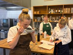 En gruppe elever i forklæde dufter og smager på forskellige tangarter i Det grønne laboratorium, hvor der eksperimenteres med mere bæredygtig gastronomi.