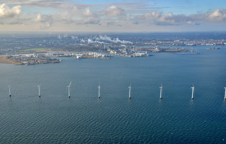 Et billede af København taget fra luften med vandet i forgrunden og byen i baggrunden.