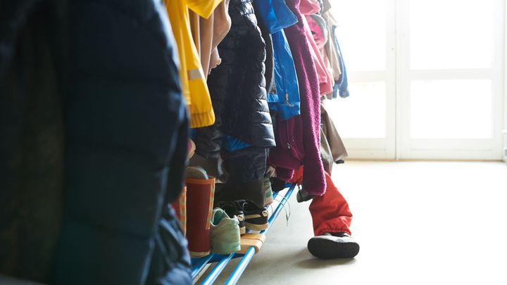 Foto af overtøj i en garderobe i en børneinstitution