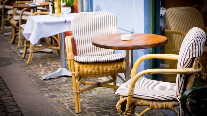 Tomme stole og caféborde foran restaurant