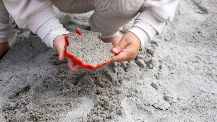 Lille barn der leger i en sandkasse