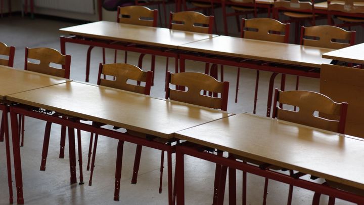 Tomt klasselokale med borde og stole.