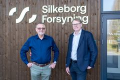 To mænd foran træbygning