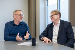 To glade mænd ved skrivebord