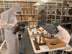 ZDF-fotograf Patrik Åkesson filmer, mens en af de konservatorstuderende i det særlige rengøringsteam nænsomt tager et af samlingens modelskibe under behandling. Alle magasinets genstande støvsuges, rengøres og gennemgås for skimmel og andre trusler, der kan nedbryde kulturarven.