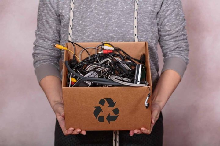 Mand holder kasse med brugt småelektronik