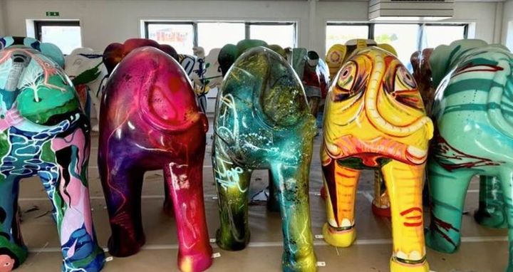 Fem dekorerede og farvestrålende elefantfigurer set bagfra